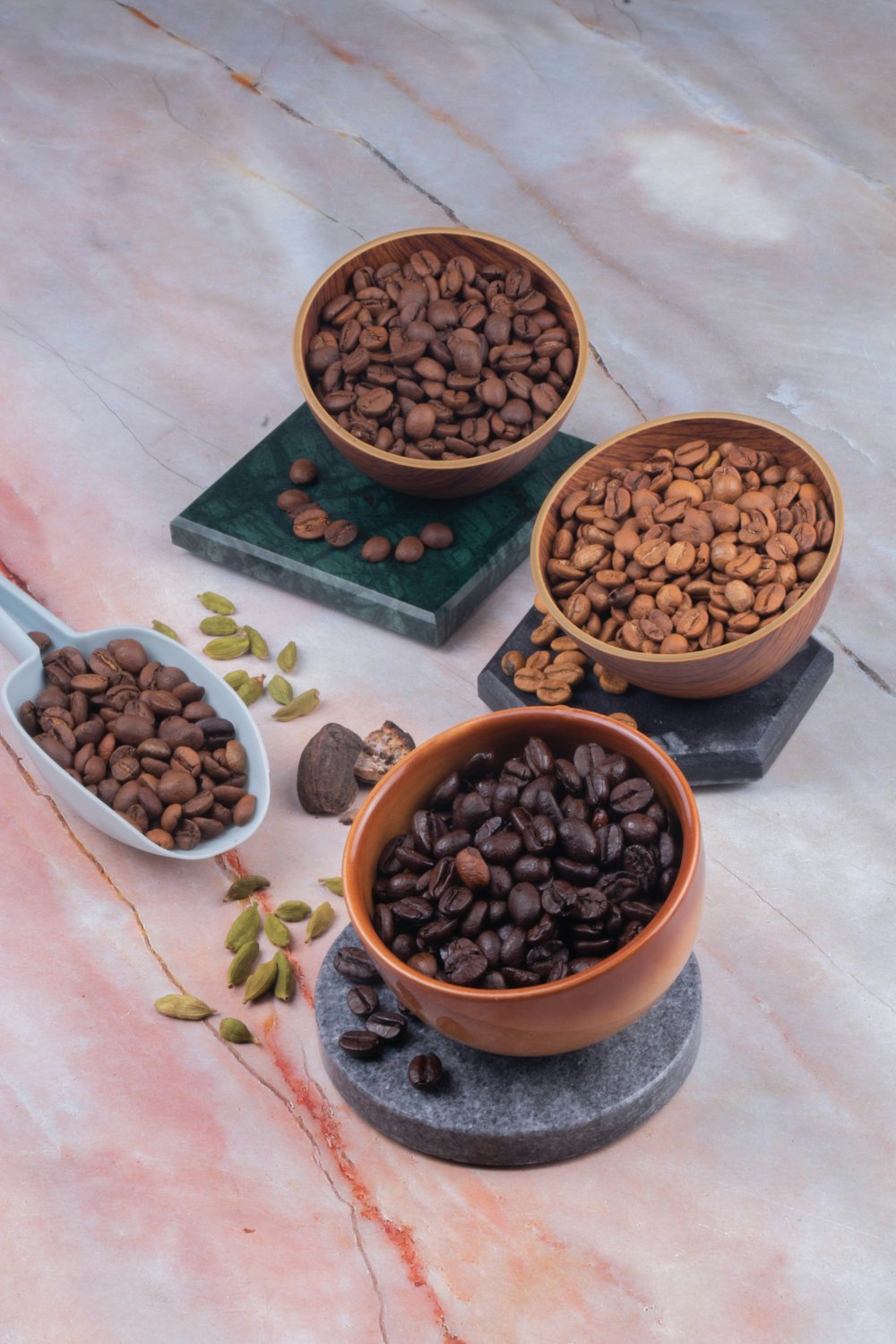 three bowls filled with coffee beans on top of a counter