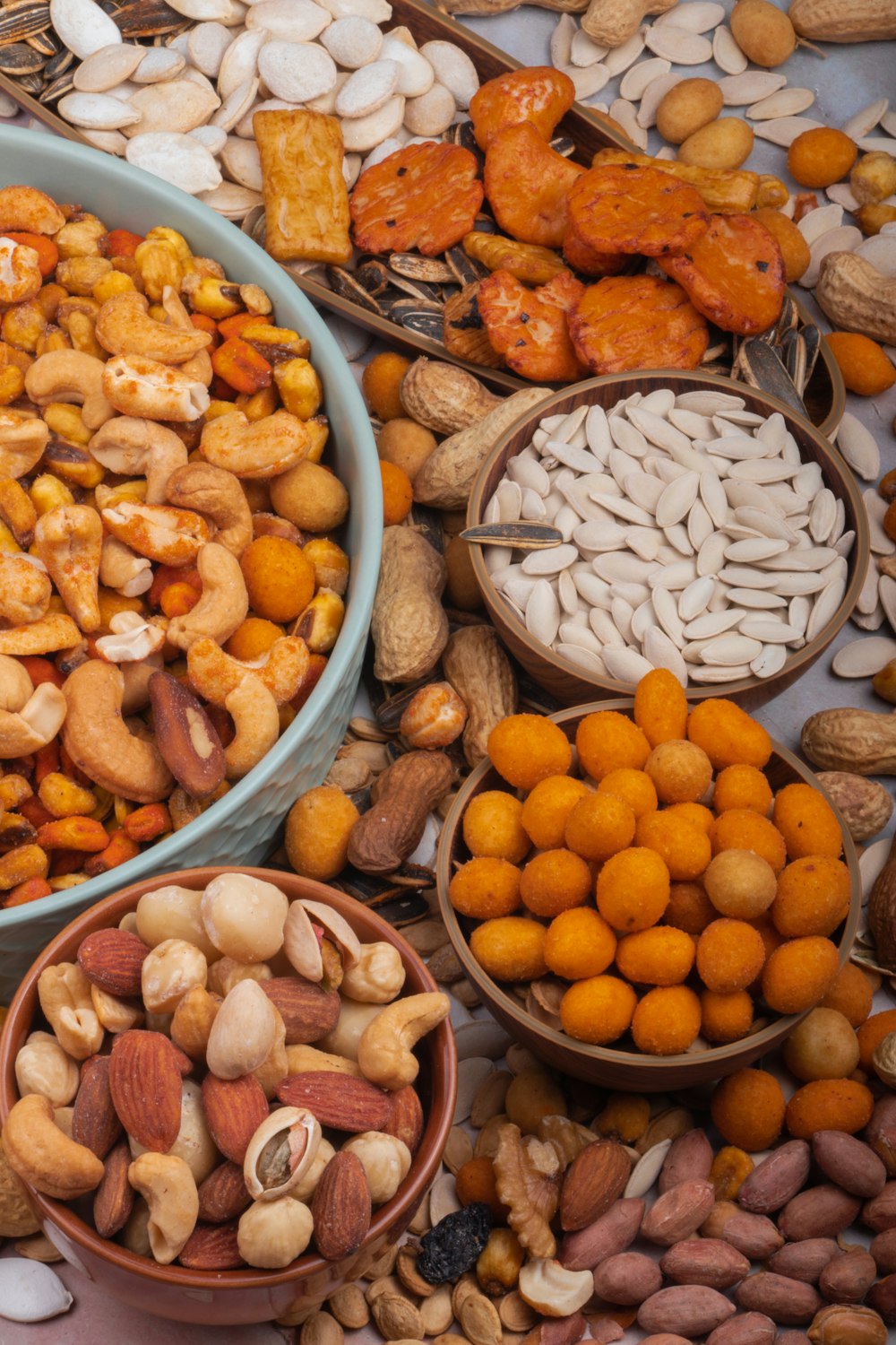 a variety of nuts in bowls on a table