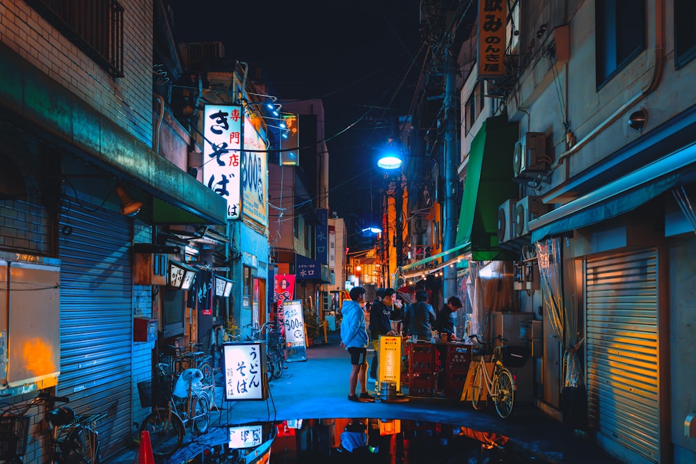 a city street at night with people walking around