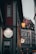 A narrow street featuring a building with a bright sign for Casa Italia, a hotel and pizzeria. The area is dimly lit, with ambient lighting from street lamps, creating a cozy atmosphere. Adjacent buildings show classic architecture with decorative facades.