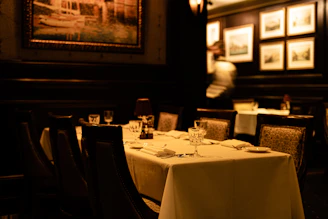 a dimly lit dining room with white table cloths