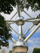 A stainless steel pyramid structure surrounded by greenery.