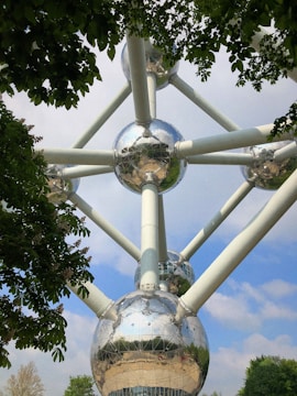 A stainless steel pyramid structure surrounded by greenery.