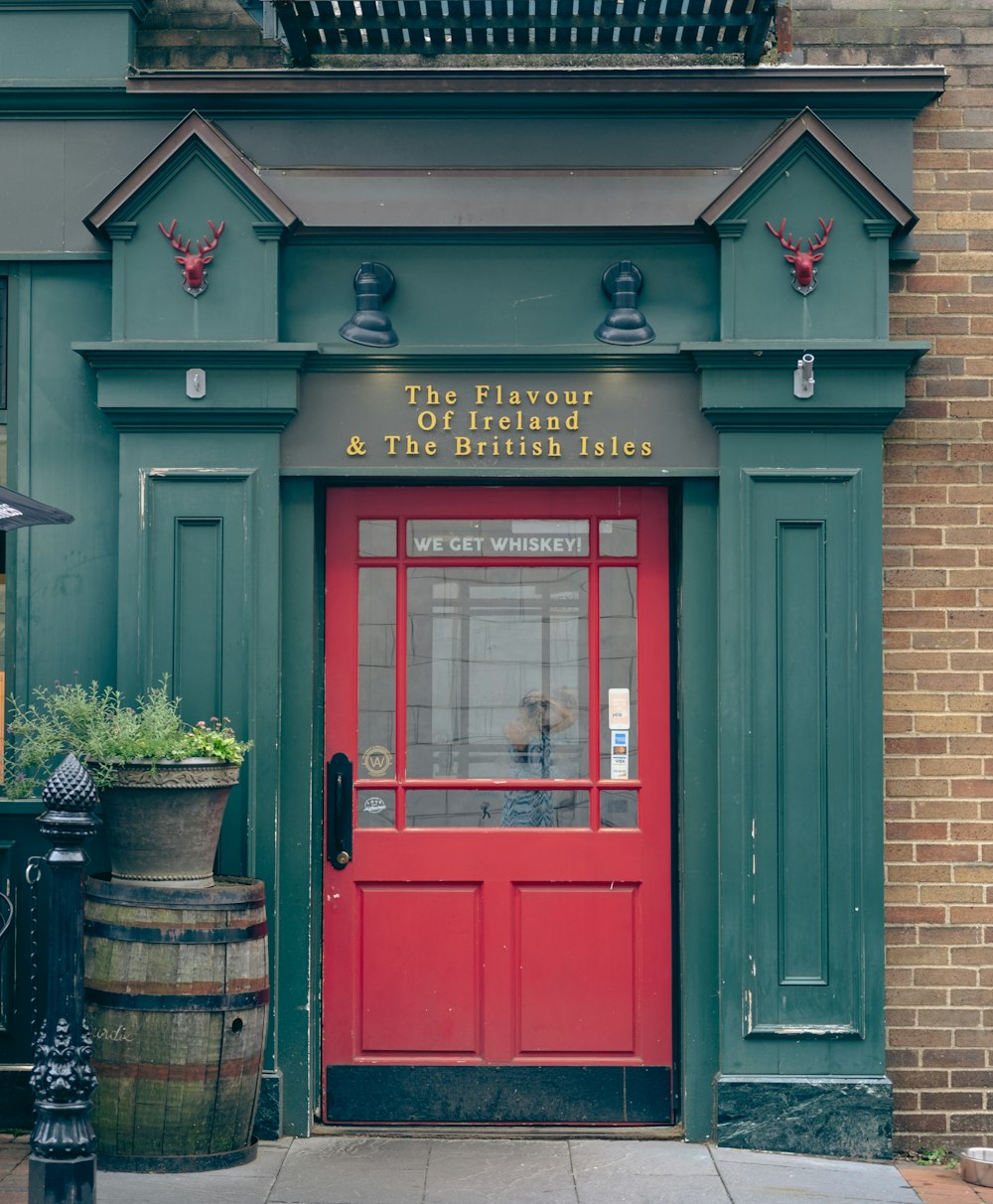 Una puerta roja en un edificio verde