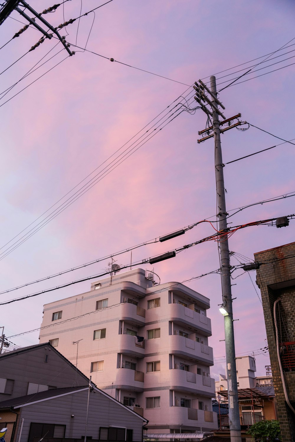 Un edificio alto y blanco sentado junto a las líneas eléctricas