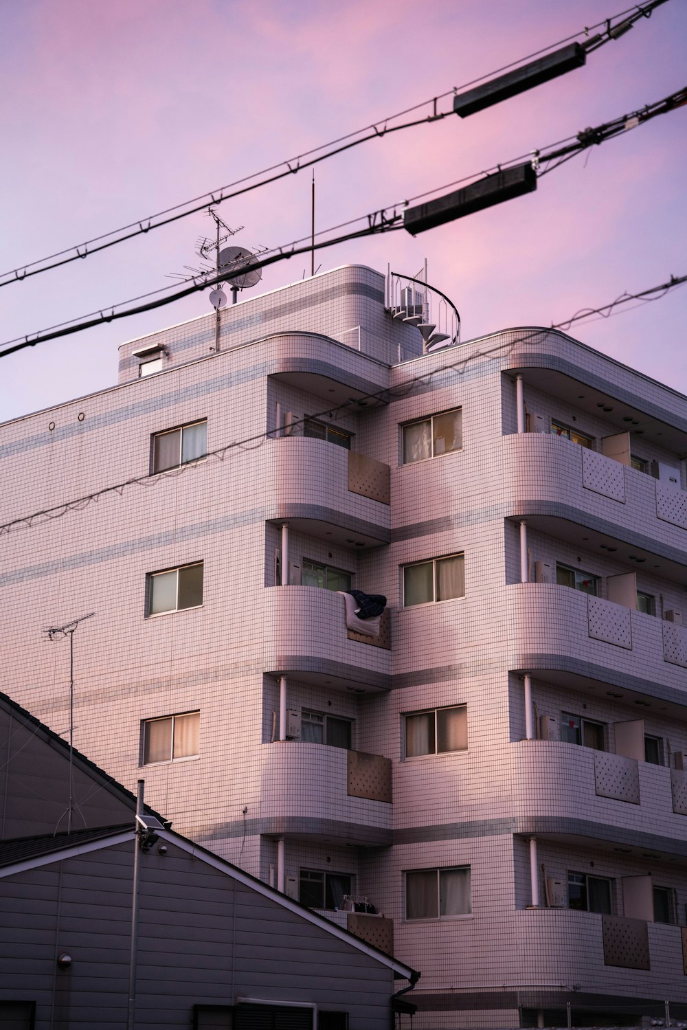 an apartment building with a pink sky in the background