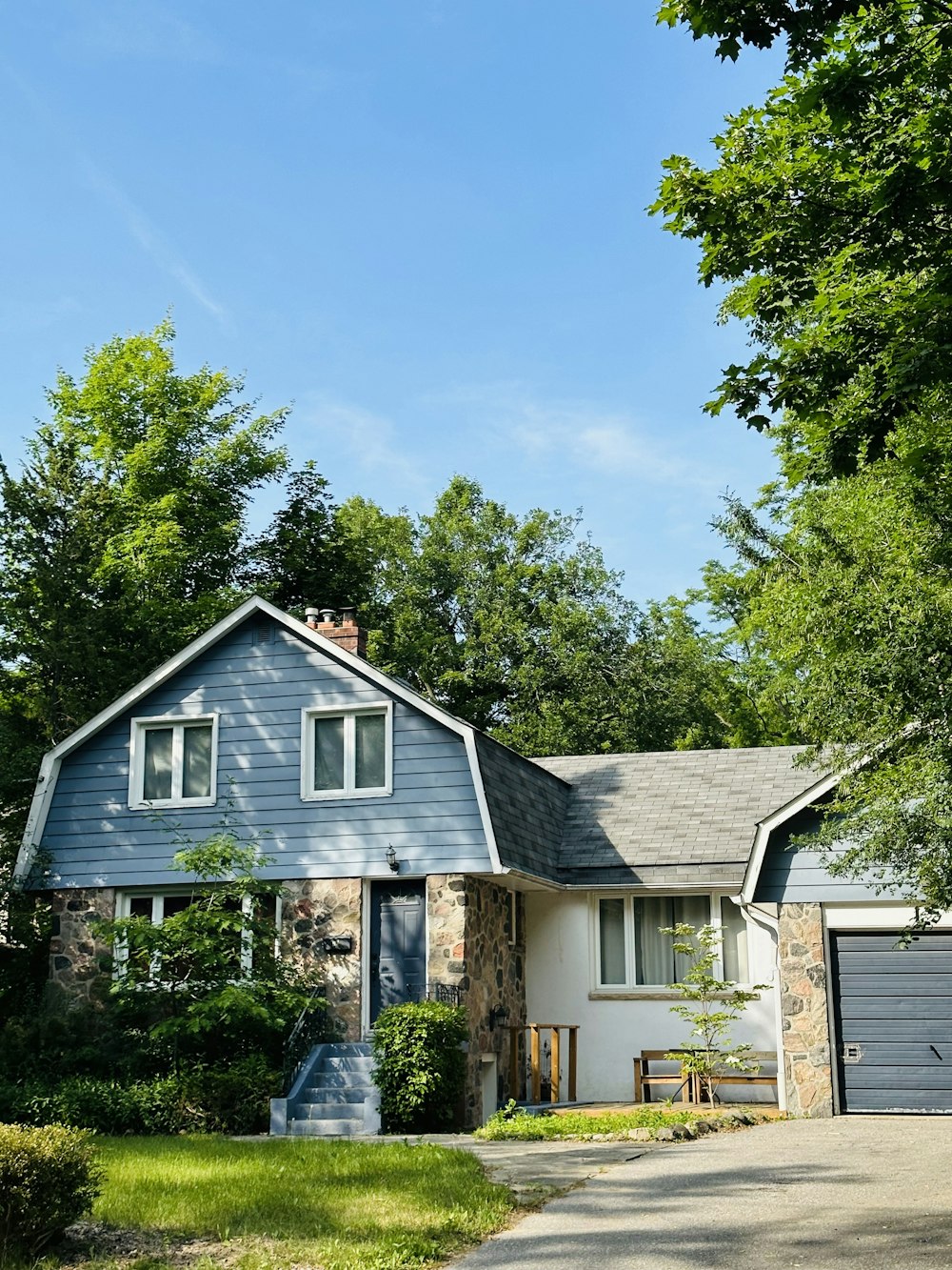 a blue house with a driveway in front of it