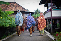 A group of travelers exploring a colorful African village with Pio leading the way.