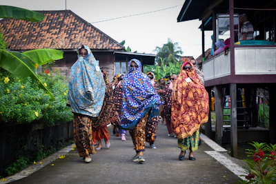 A group of travelers exploring a colorful African village with Pio leading the way.