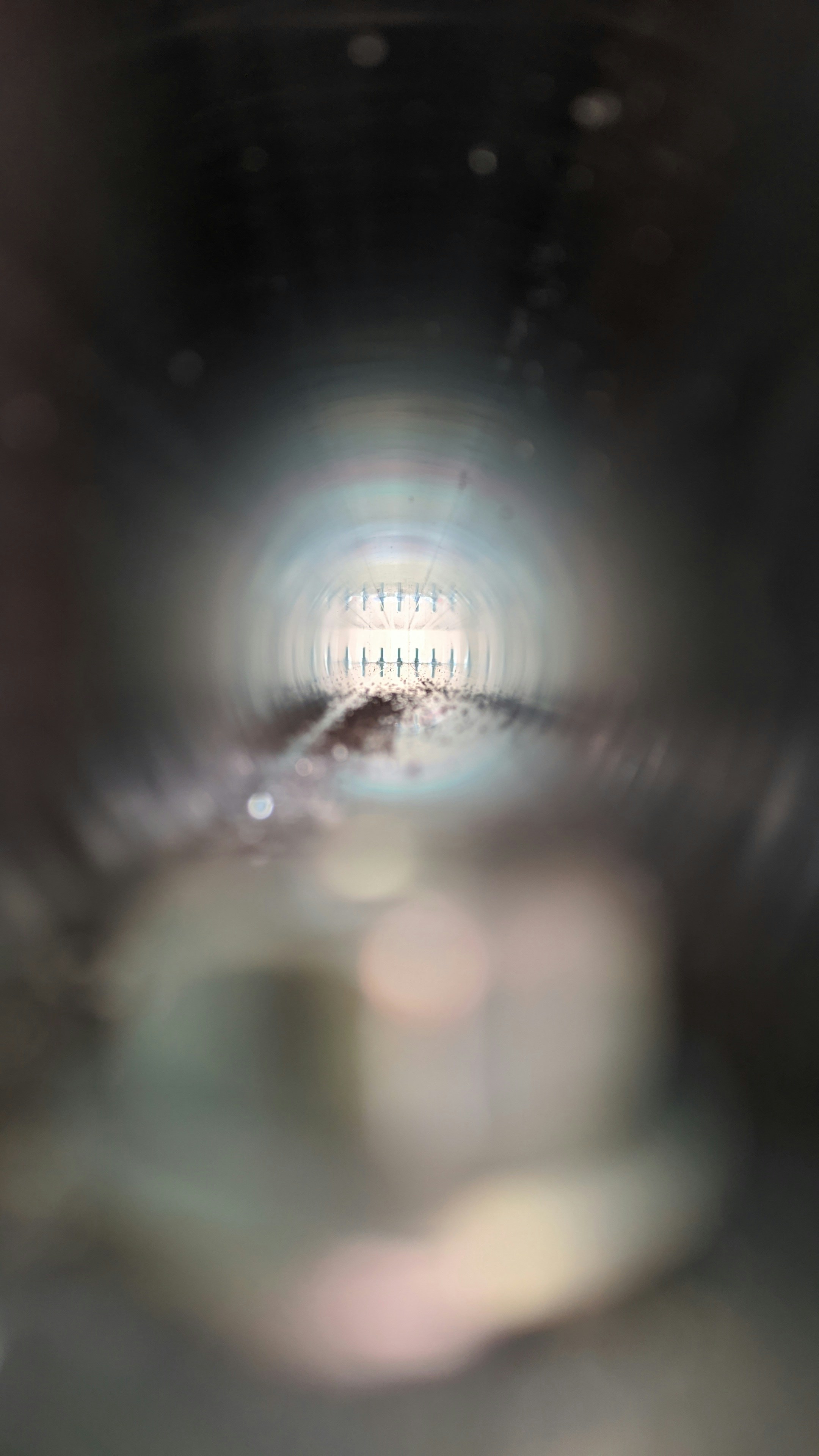 a blurry photo of a light in the middle of a tunnel
