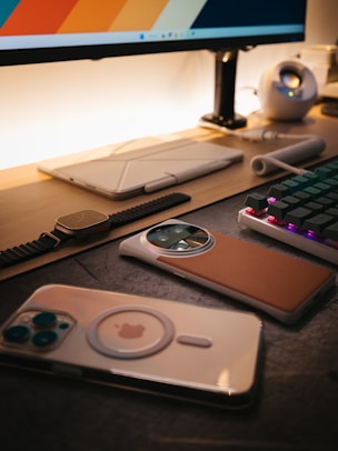 a computer desk with a keyboard, mouse, and cell phone