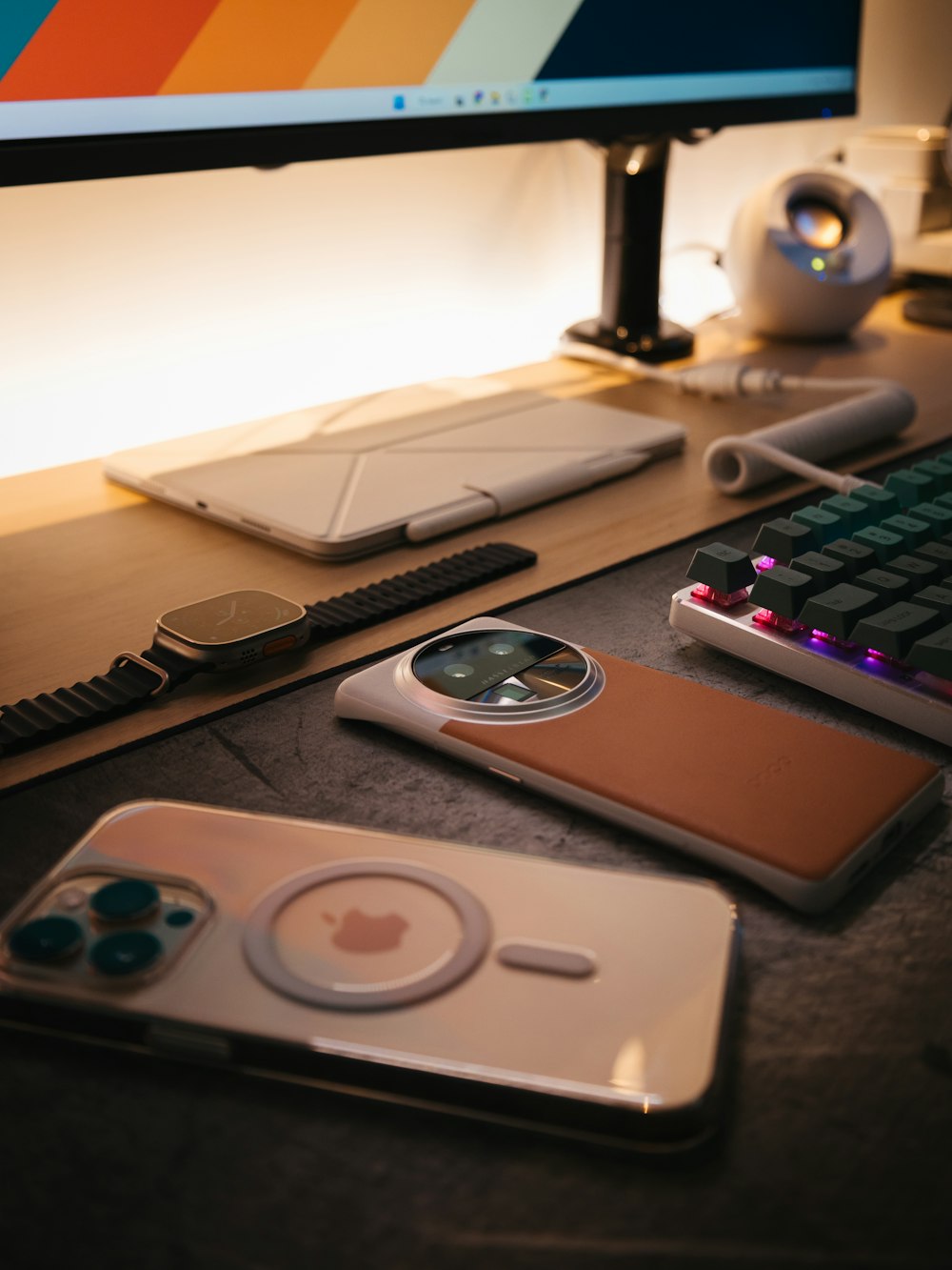 a computer desk with a keyboard, mouse, and cell phone