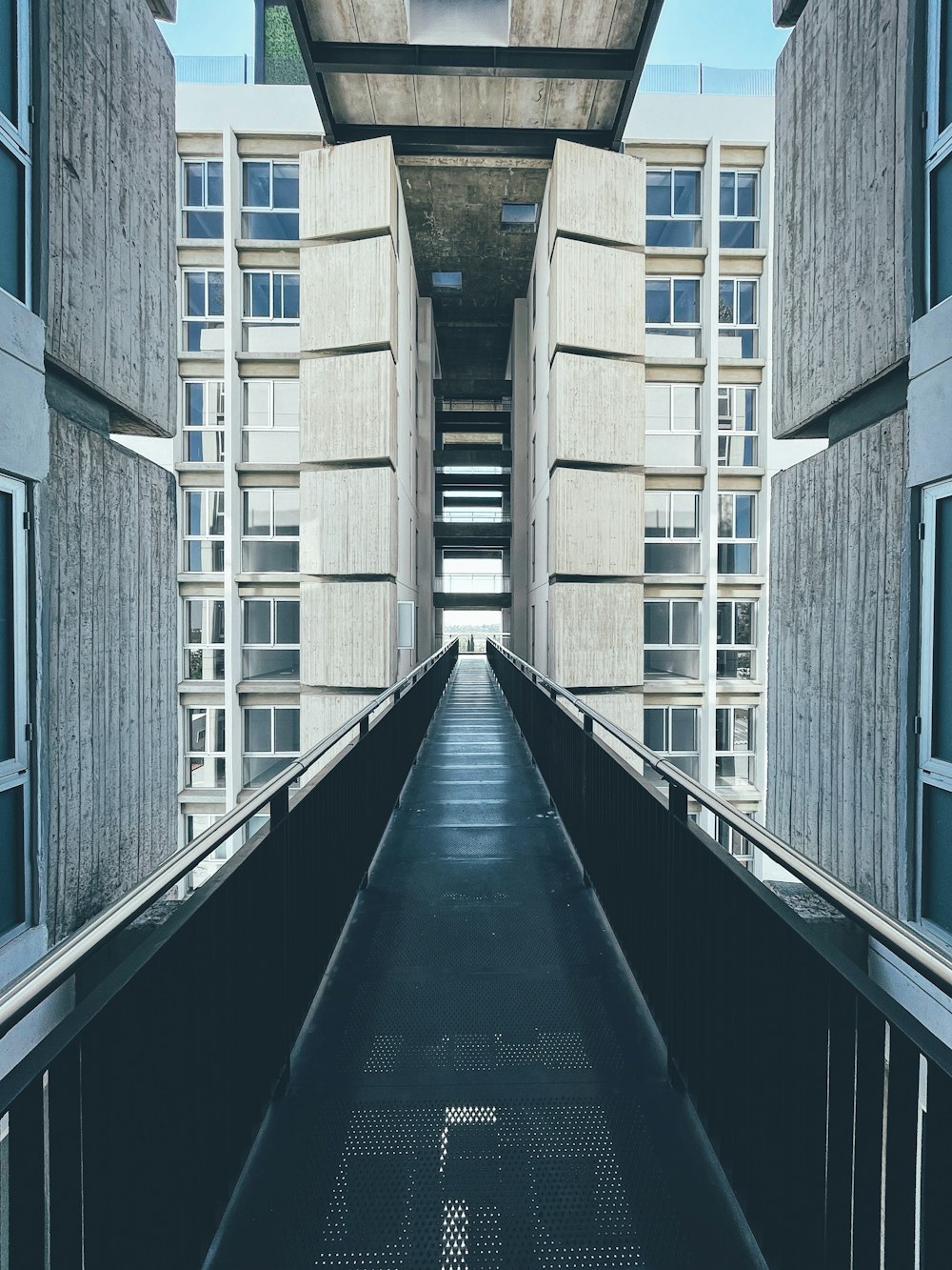 une longue passerelle entre deux bâtiments avec une horloge au sommet