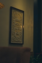 A close-up of a beautifully framed artwork hanging on a bright wall, highlighting intricate details and colors.