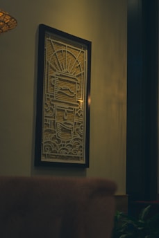 A close-up of a beautifully framed artwork hanging on a bright wall, highlighting intricate details and colors.