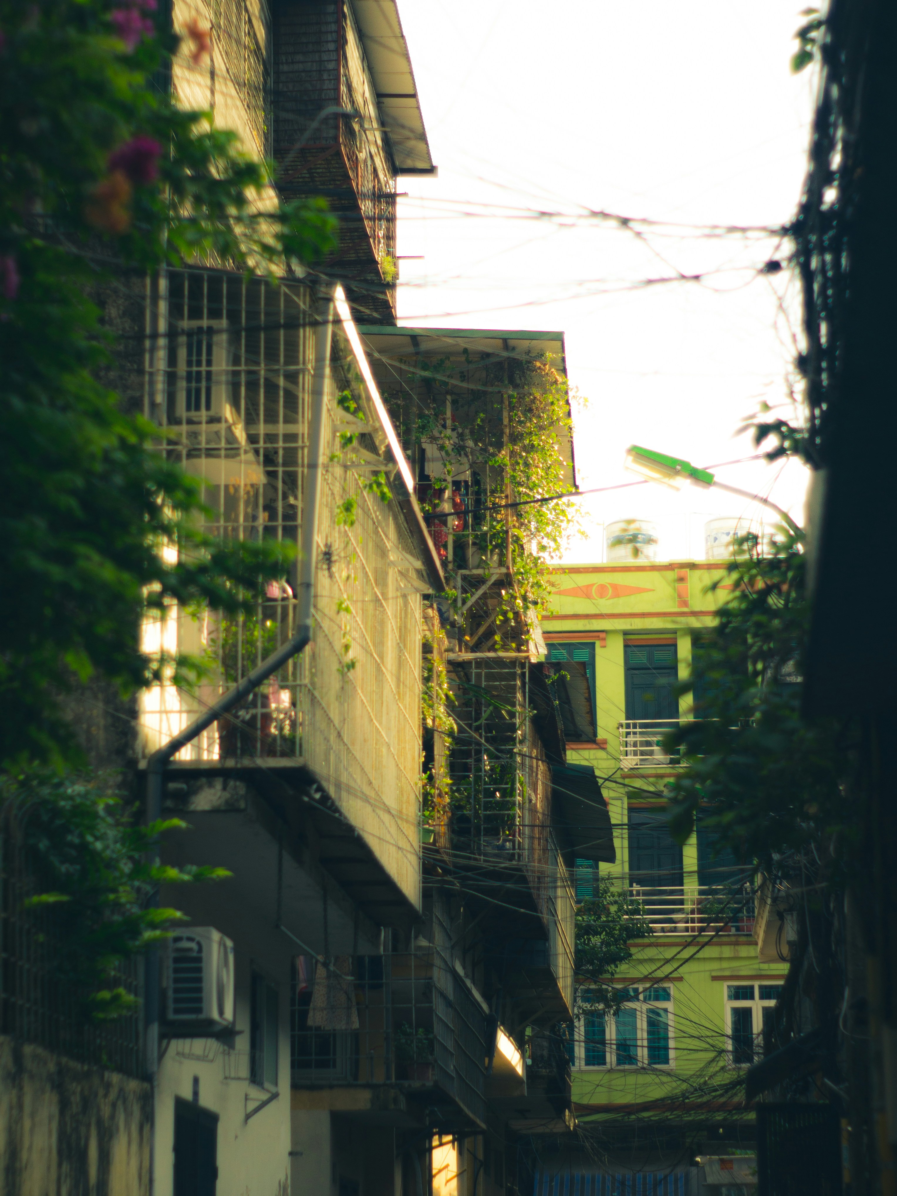 a narrow alley way with a building and a balcony