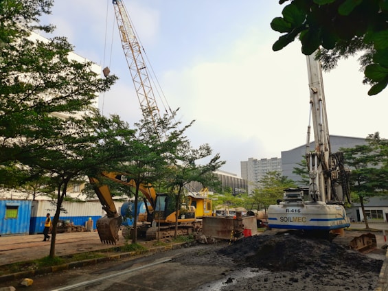 A skilled construction team collaborating on a building site with heavy machinery in the background.