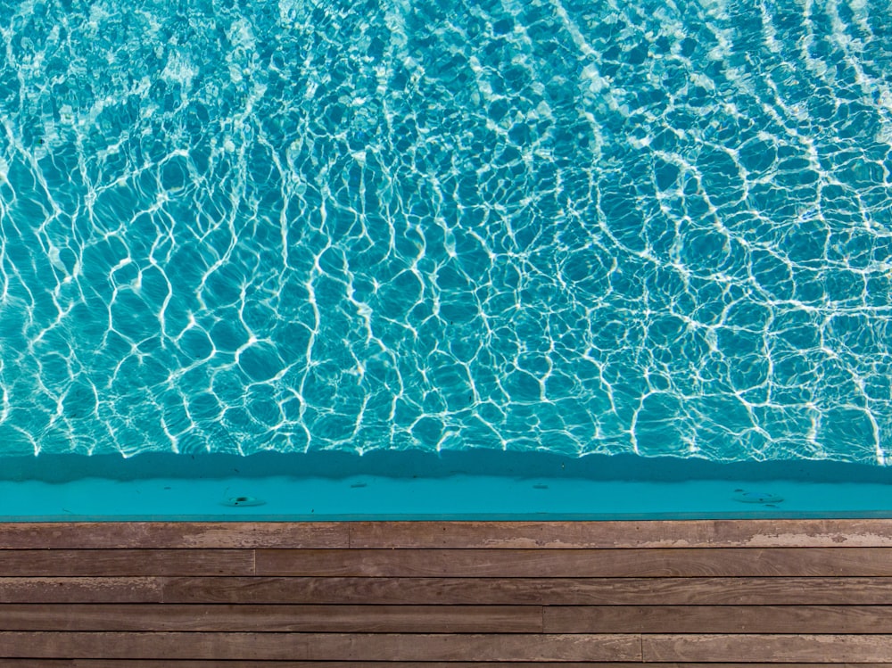 an aerial view of a pool with a wooden deck