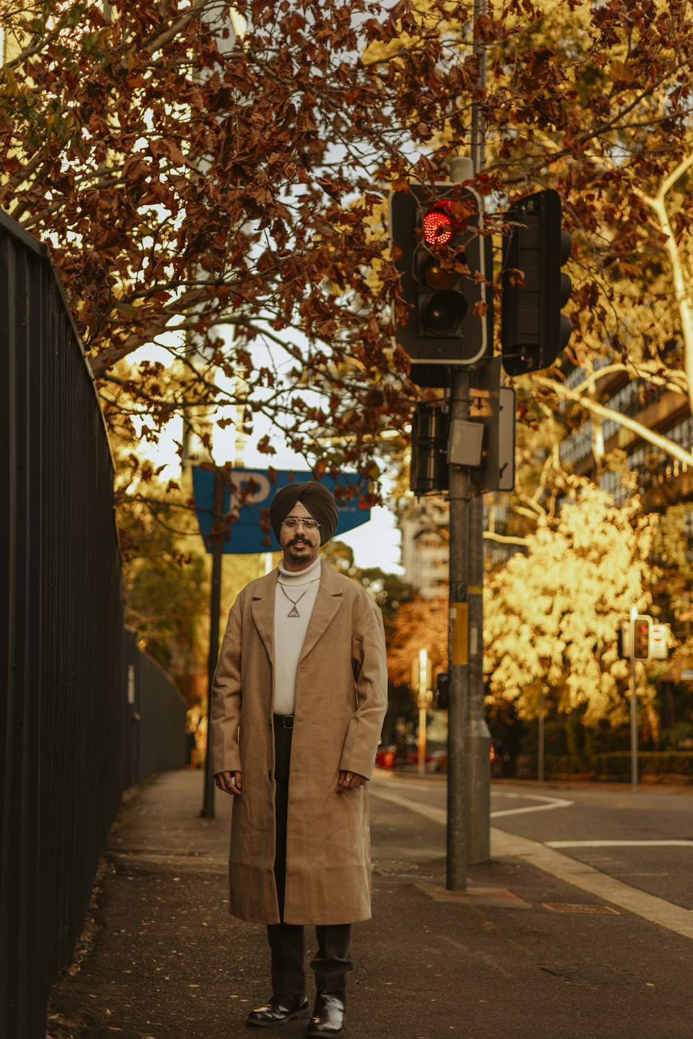 a man standing on the side of a road next to a traffic light