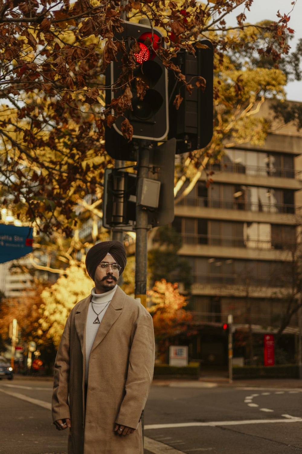 a man standing on the side of a road next to a traffic light