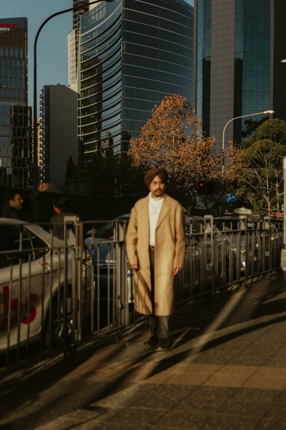 a man walking down a street next to tall buildings