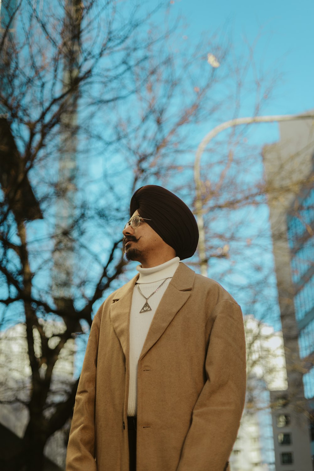 a man with a turban standing in front of a tree