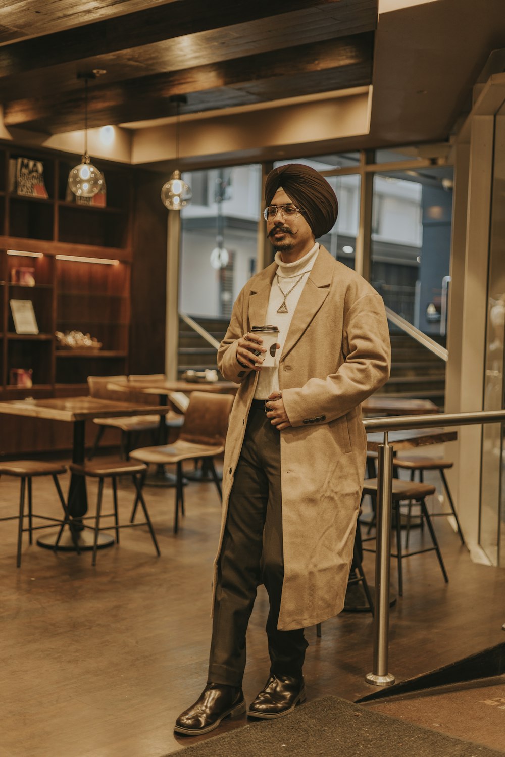 a man standing in a restaurant holding a cup of coffee