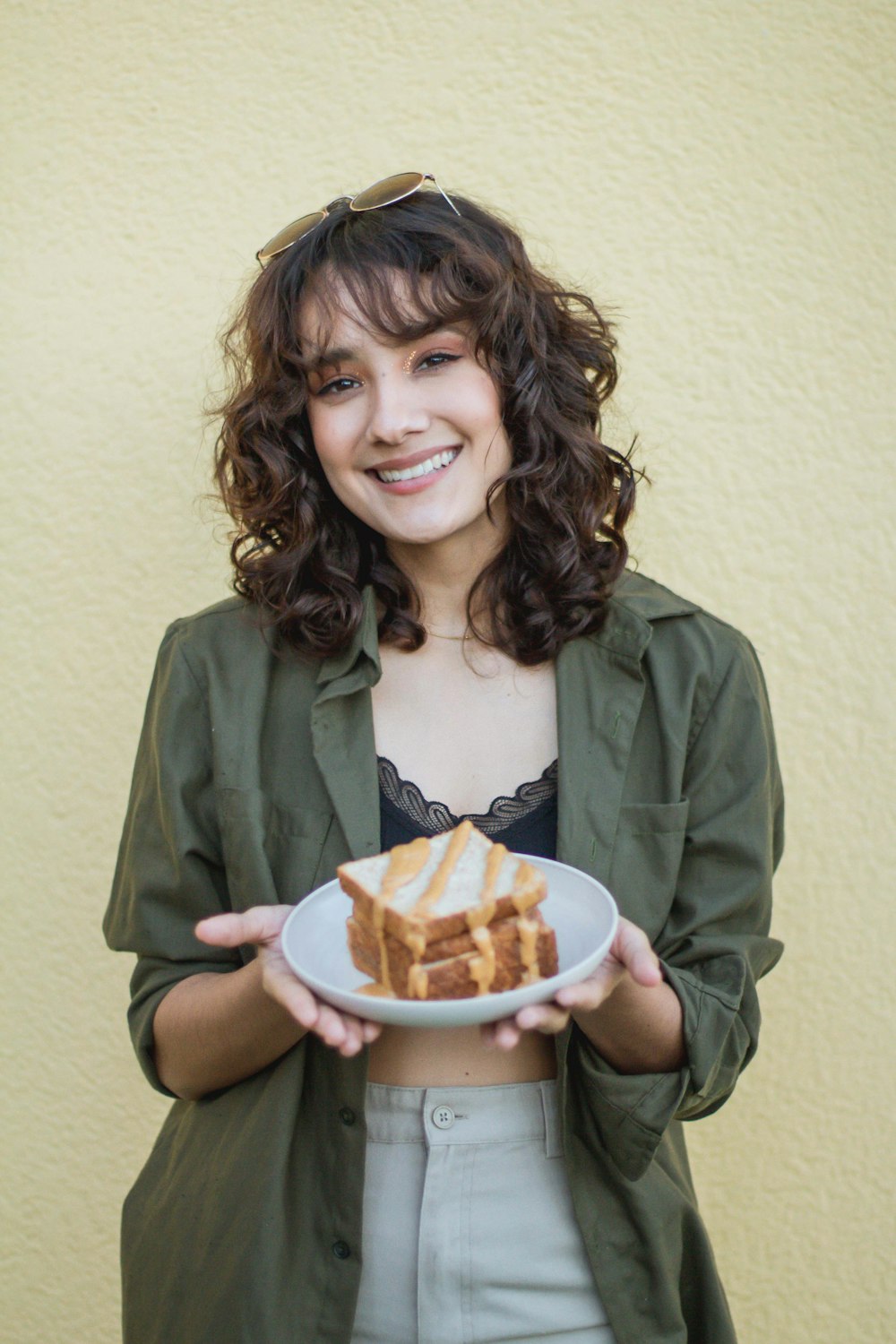 a woman holding a plate with a piece of cake on it