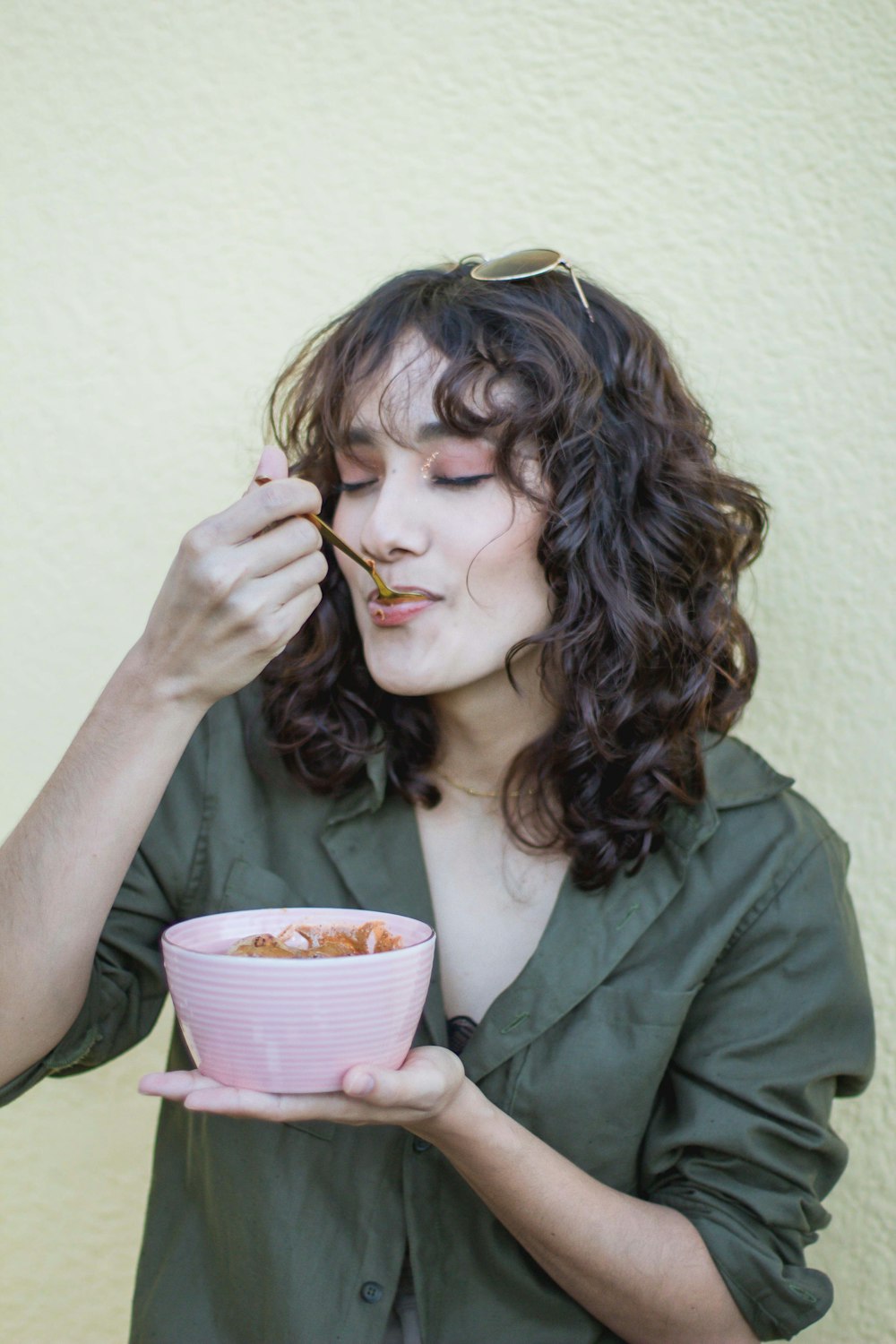 a woman holding a pink bowl of food