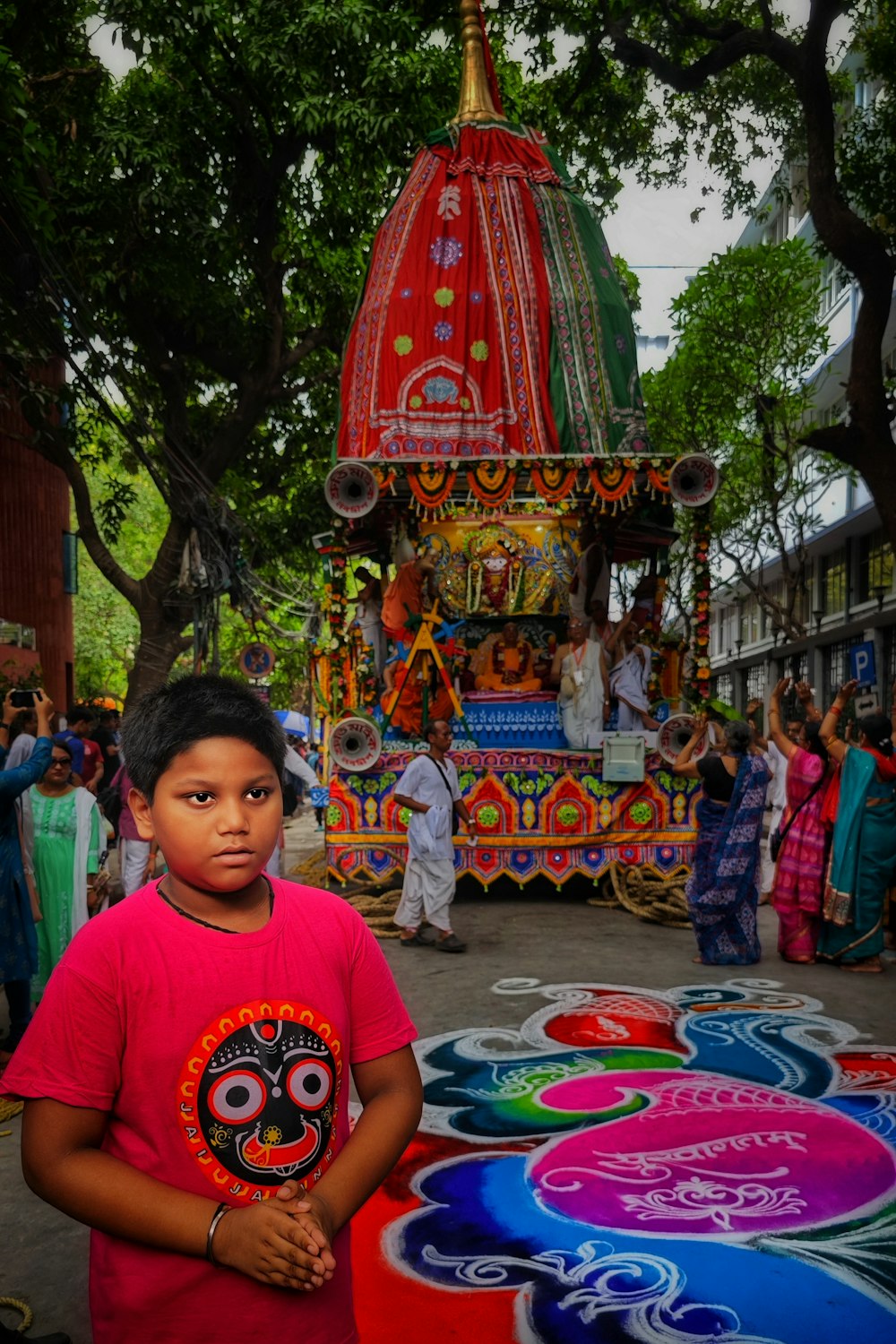 a young boy standing in front of a colorful float