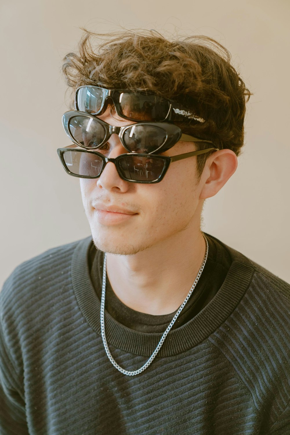 a young man wearing sunglasses and a necklace