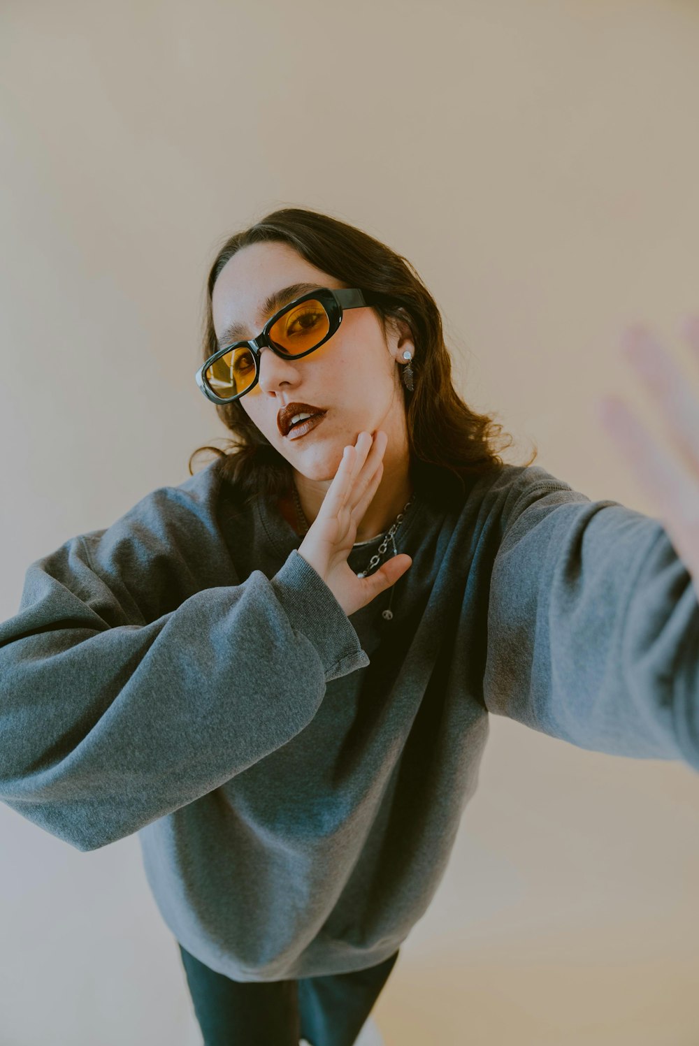 a woman in a gray sweater and yellow sunglasses