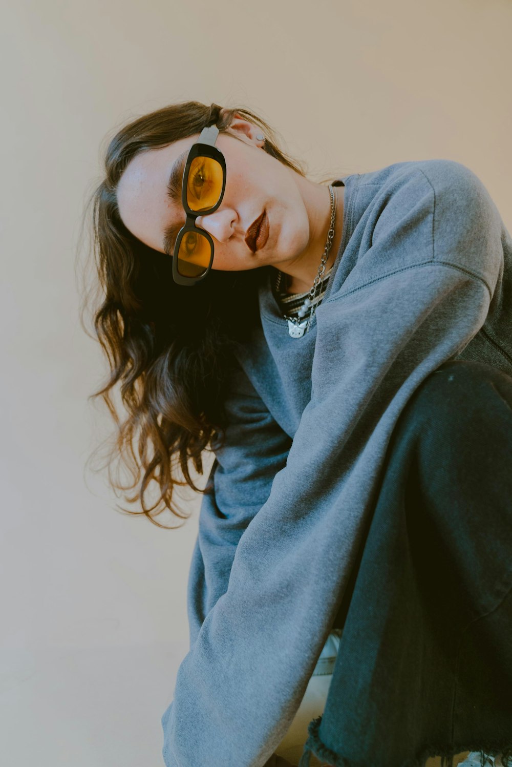 a woman wearing sunglasses sitting on the ground