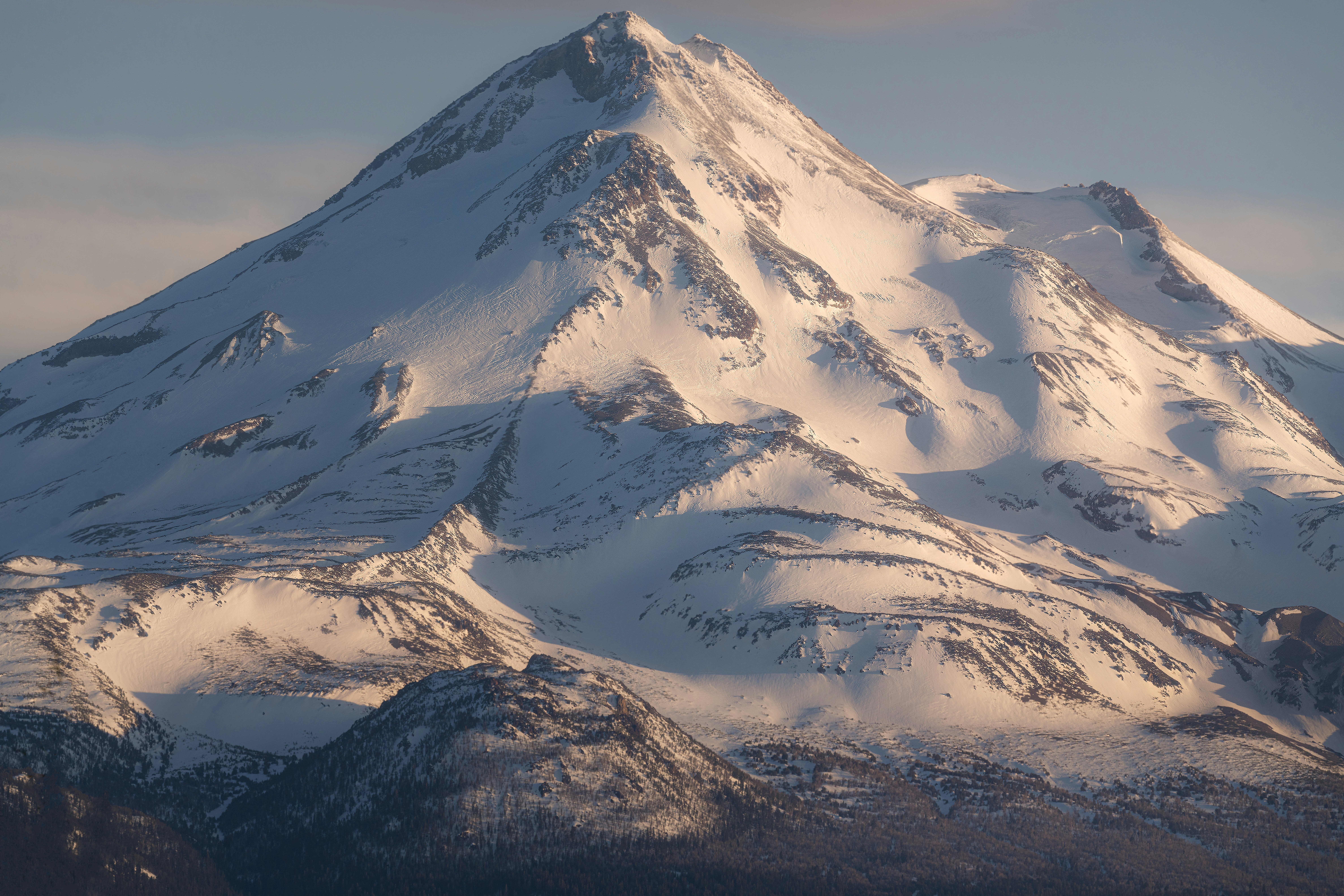 a large snow covered mountain in the middle of the day, Light and shadows during sunset at Shasta