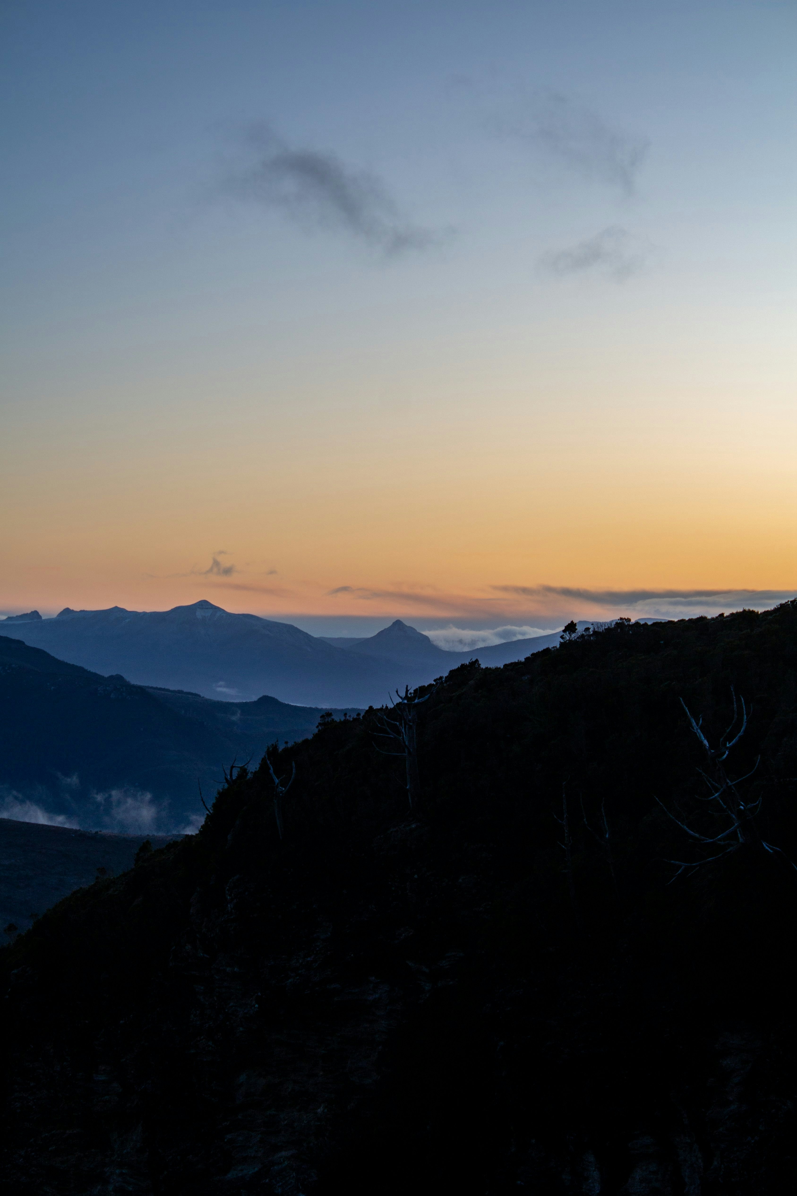 a person standing on top of a mountain at sunset