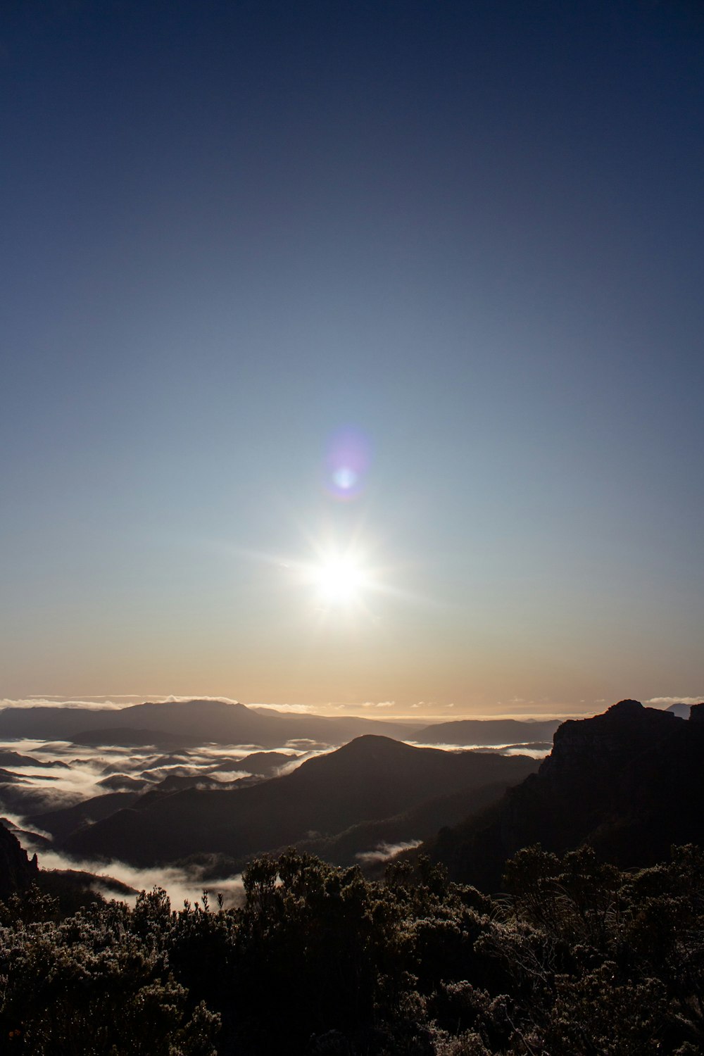 the sun is setting over a mountain range