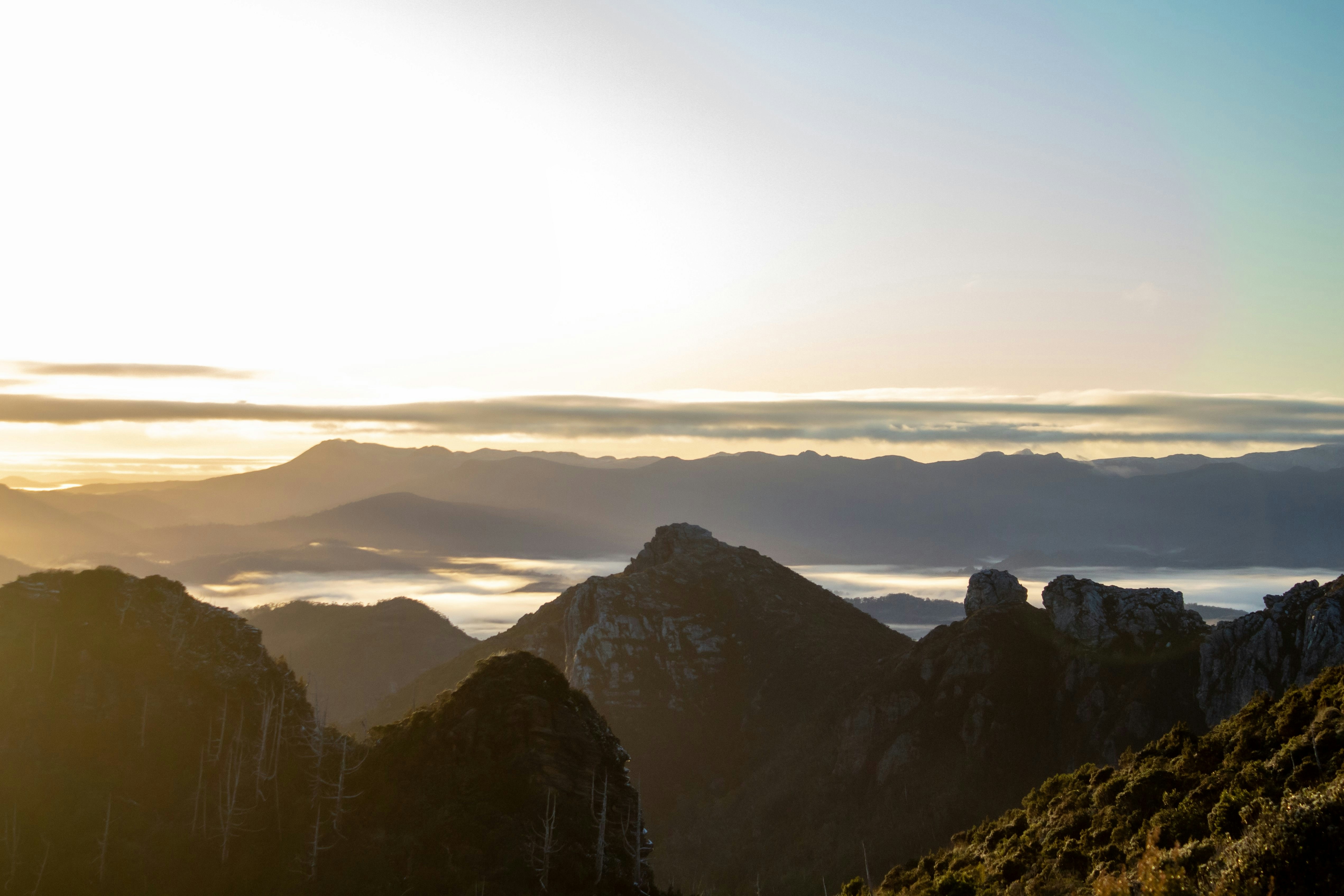 a person standing on top of a mountain with a sky background, 
