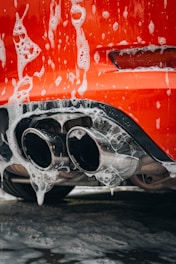 a close up of a red car with water on it