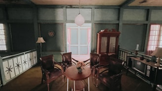 A vintage-style room with a wooden round table in the center surrounded by four leather chairs. There is a large wooden cabinet in the back, a floor lamp, a retro television, and a decorative plate on the wall. The lighting is soft, and the room features muted green walls and a floral centerpiece on the table.