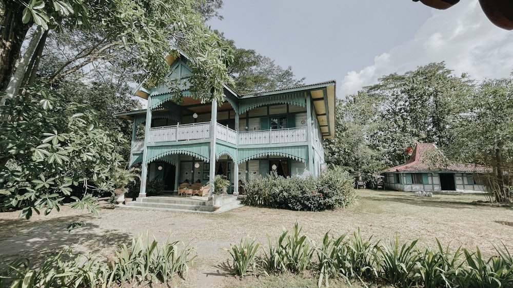 a large blue house sitting in the middle of a forest