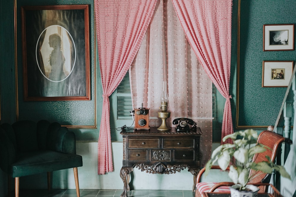 a living room filled with furniture and a pink curtain
