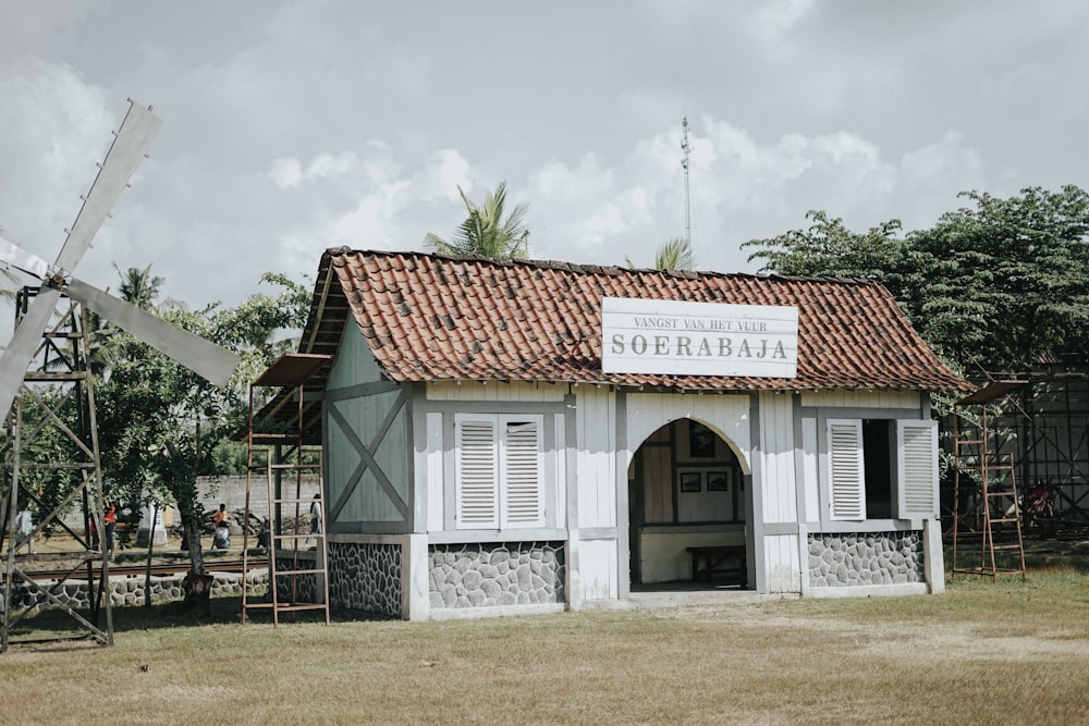 a small building with a windmill in the background