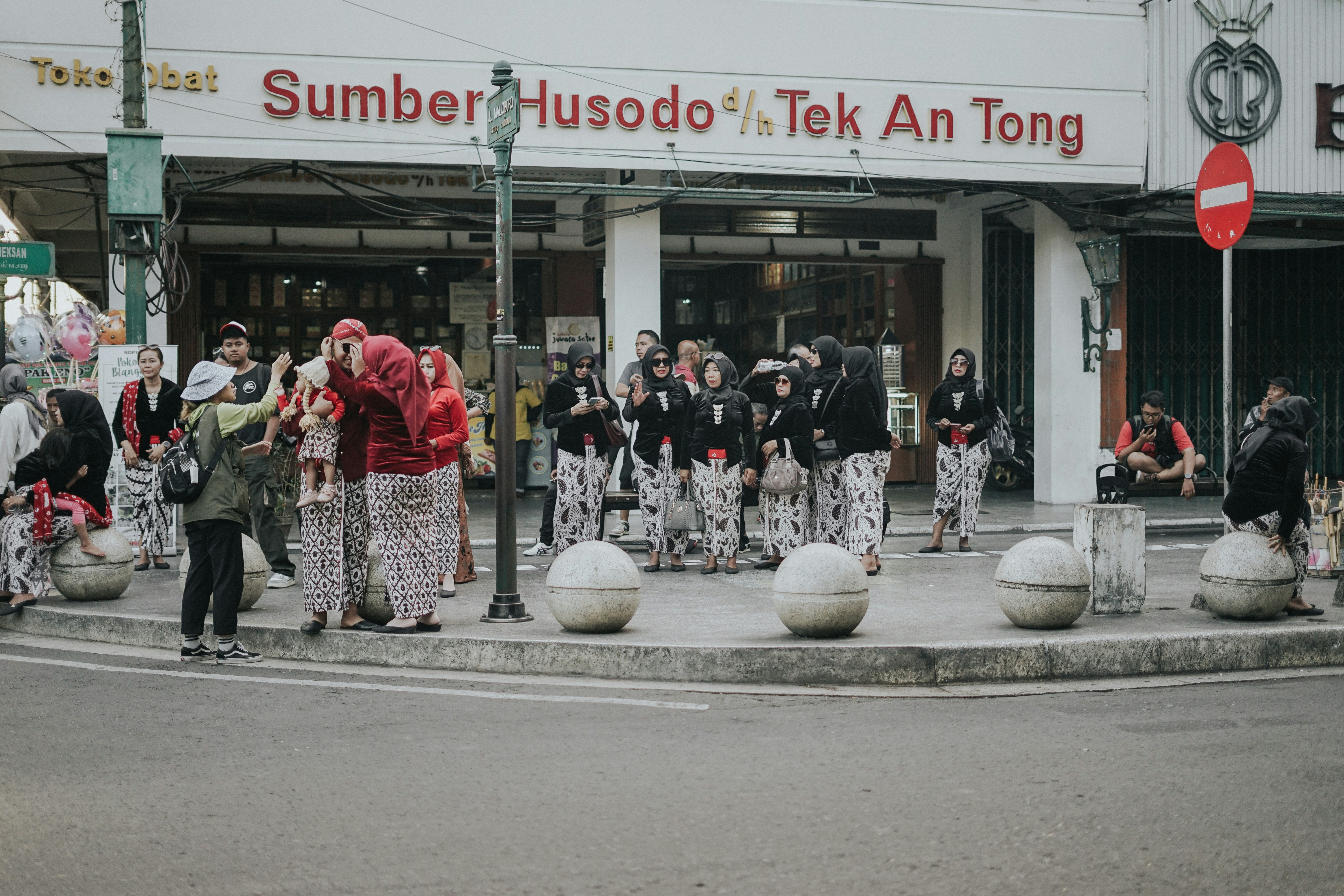 a group of people standing on the side of a road