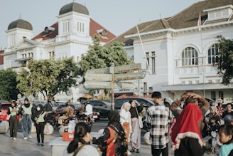 a crowd of people walking down a street next to tall buildings