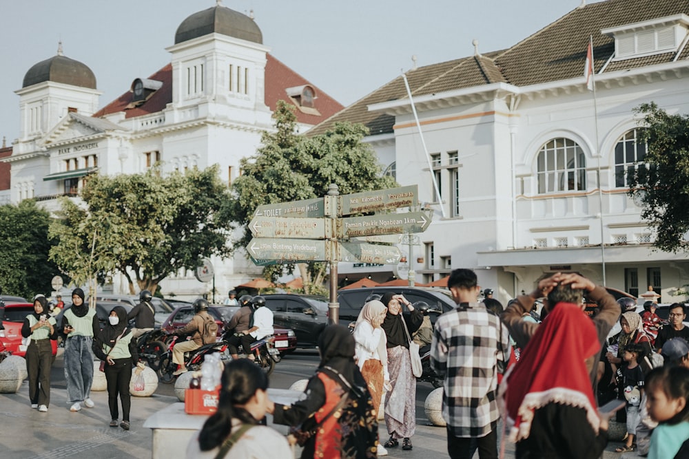 a crowd of people walking down a street next to tall buildings