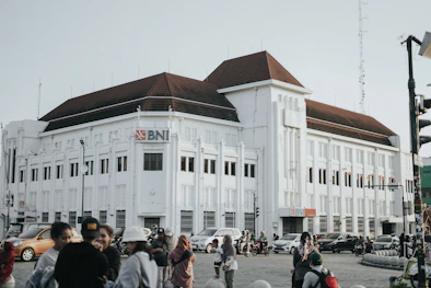 a large white building with a lot of people walking around it