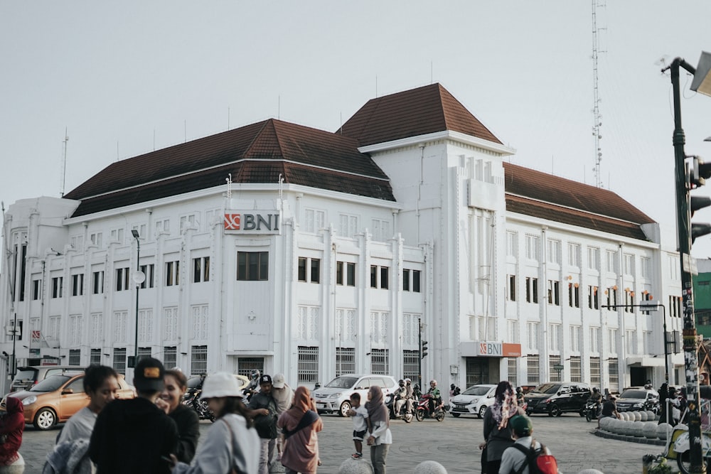 a large white building with a lot of people walking around it