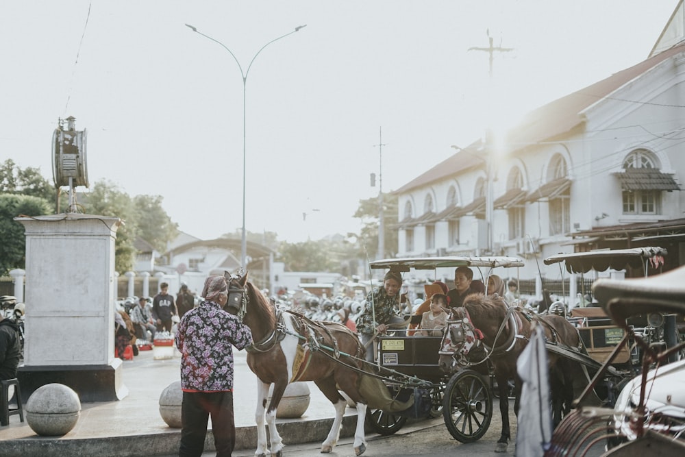 a man standing next to a horse drawn carriage