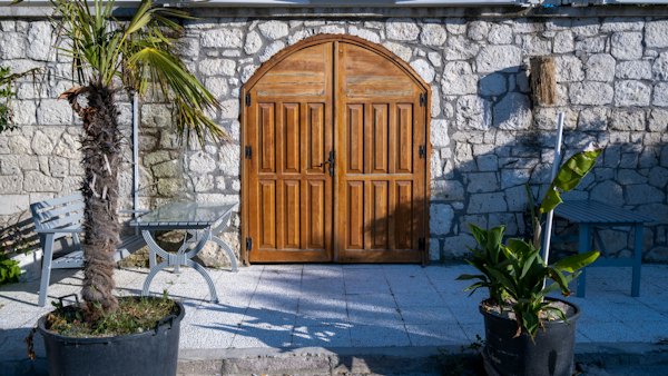 A stone building with a wooden door and two chairs — Çeşme & Alaçatı, Turkey