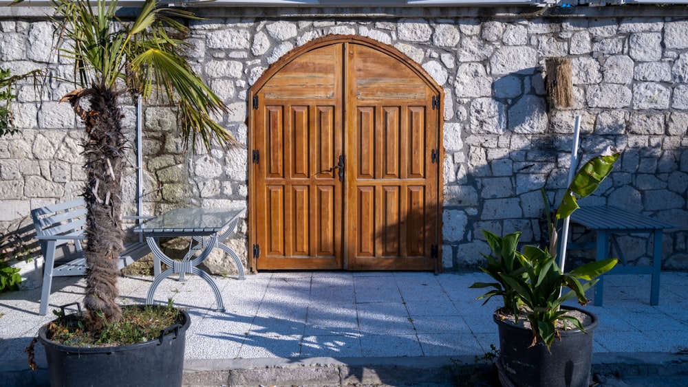 a stone building with a wooden door and two chairs